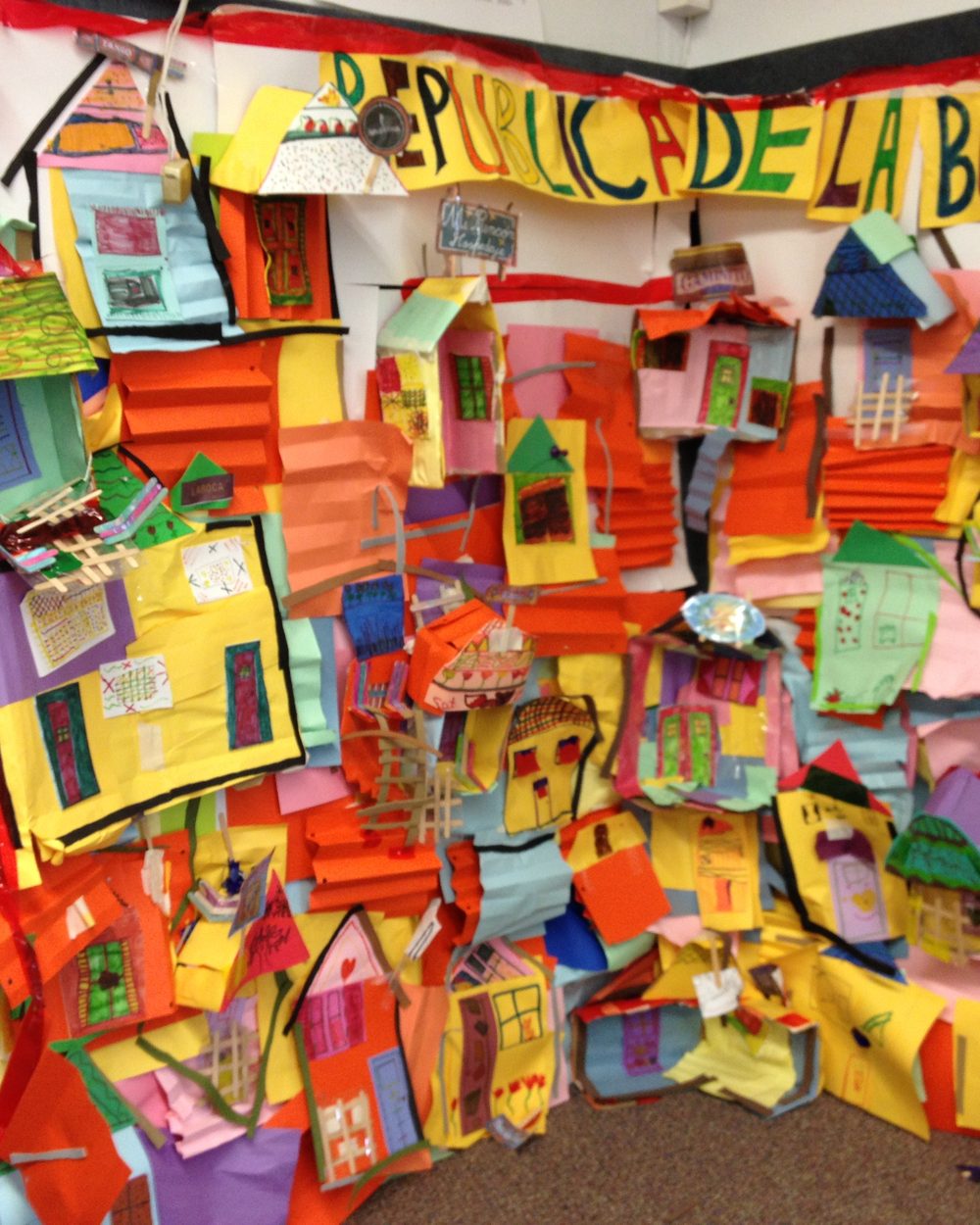 A classroom mural of paper houses titled República de La Boca, built by the children