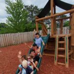 A group of people riding down the side of a slide.