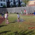 A group of children playing with water in the yard.