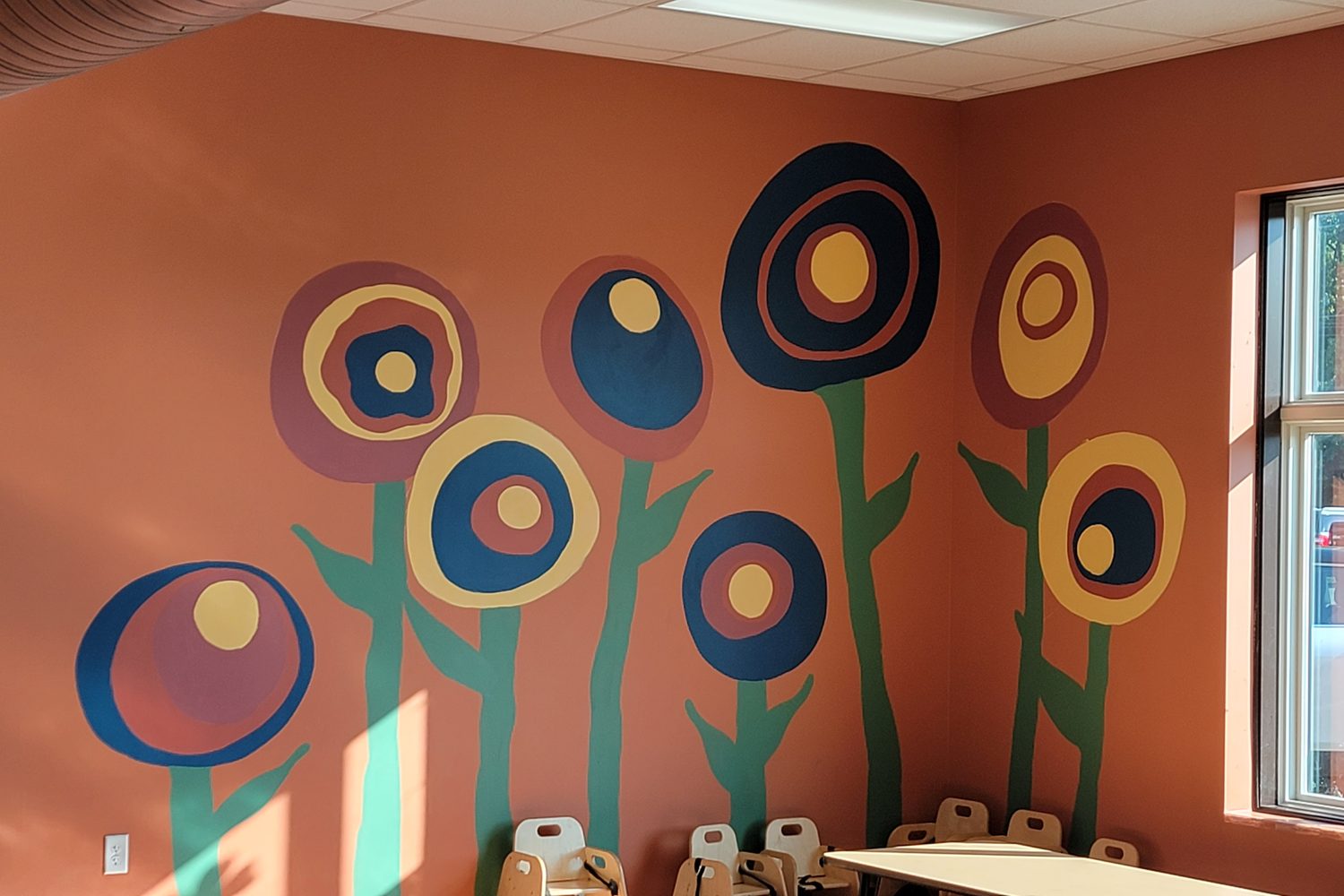 A Roseville classroom wall painted with tall, bold flowers