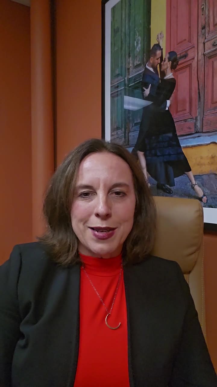Leah Retamozo seated in her office in front of an orange wall, talking to camera about parent communication